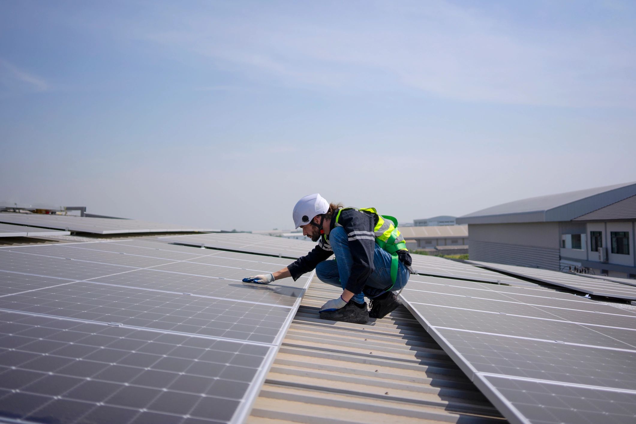 Blue collar worker install solar panel on rooftop.