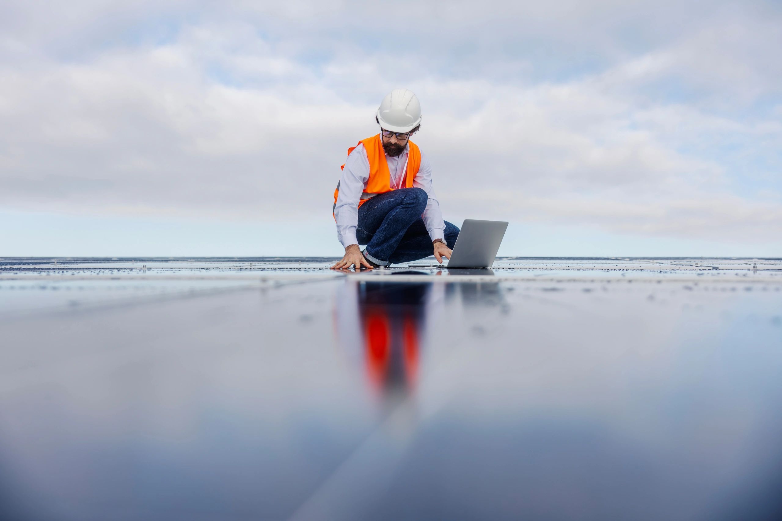 Engineer examining solar panel roof with a laptop